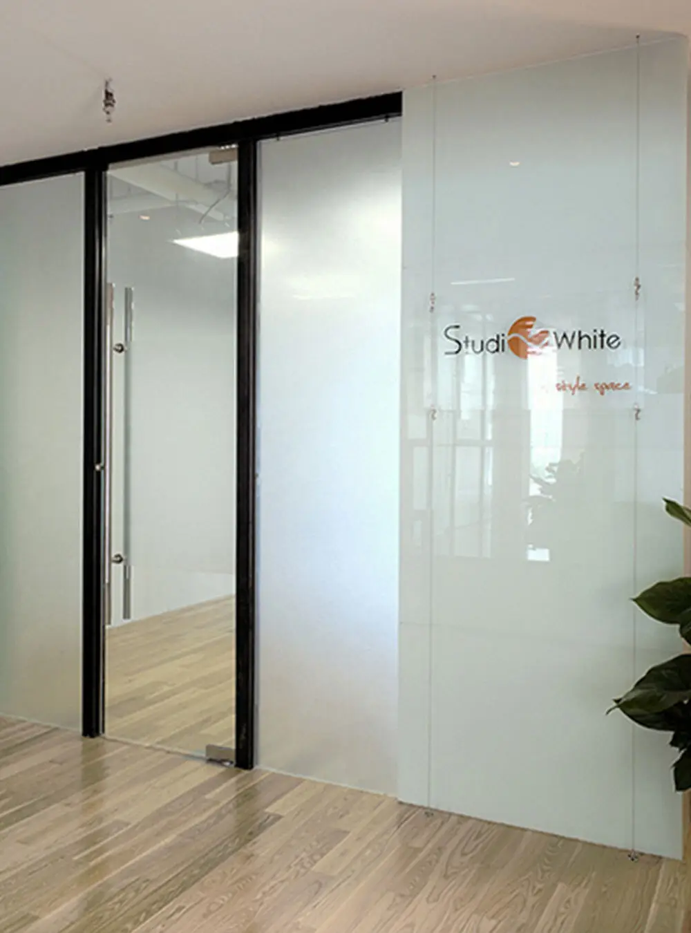 Glass office door with the Studio White logo